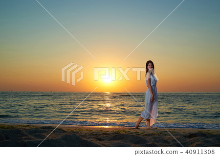 Pretty woman walking along the shore. 40911308