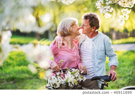 Beautiful senior couple with bicycles outside in spring nature. Beautiful senior couple with bicycles outside in spring nature. 40911899