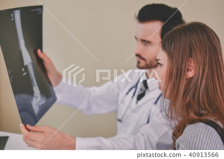 Health Concepts. Doctor and patient viewing x-ray film. The doct Health Concepts. Doctor and patient viewing x-ray film. The doct 40913566