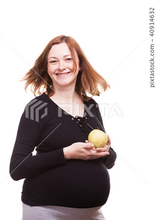 Beautiful pregnant happy woman holds an apple in her hands Beautiful pregnant happy woman holds an apple in her hands 40914632