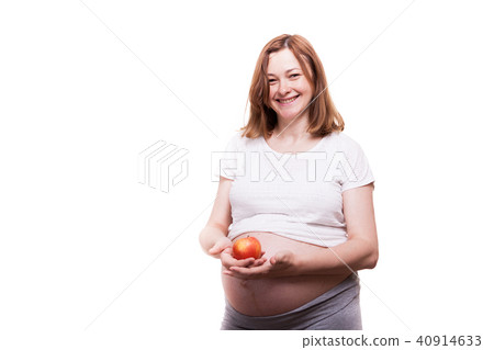 Happy pregnant woman holds a red apple in her hands Happy pregnant woman holds a red apple in her hands 40914633