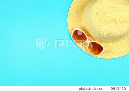 Hat, sunglasses on a pastel blue background. 40915410