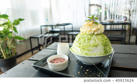 Green tea and red bean Bingsu on a wooden table. Green tea and red bean Bingsu on a wooden table. 40915624