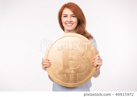 Red-haired woman holding big bitcoin on white background. Cryptocurrency investment concept. Red-haired woman holding big bitcoin on white background. Cryptocurrency investment concept. 40915972