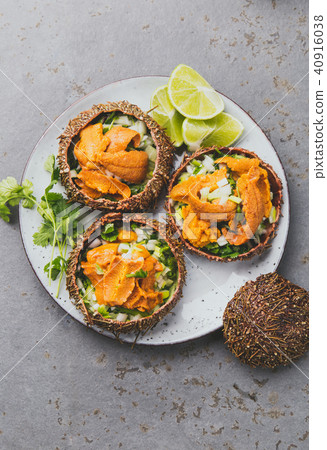 Fresh opened sea urchins. Caviar of sea urchins with onion, cilantro and lemon inside of shell of Fresh opened sea urchins. Caviar of sea urchins with onion, cilantro and lemon inside of shell of 40916038