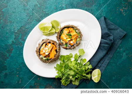 Fresh opened sea urchins. Caviar of sea urchins with onion, cilantro and lemon inside of shell of 40916043