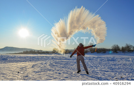 A tourist throwing hot water on ice river A tourist throwing hot water on ice river 40916294