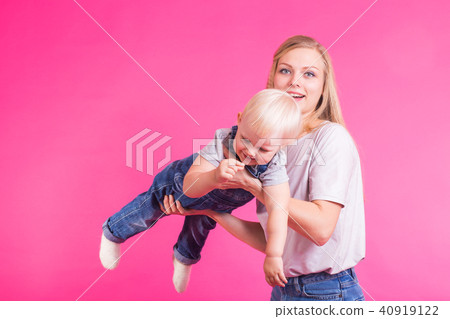 young mother and daughter having fun together on pink background 40919122