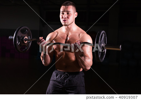 Handsome power athletic man with barbell. Strong bodybuilder with six pack, perfect abs, shoulders Handsome power athletic man with barbell. Strong bodybuilder with six pack, perfect abs, shoulders 40919307