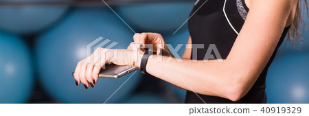 Close up of woman with fitness tracker in gym Close up of woman with fitness tracker in gym 40919329