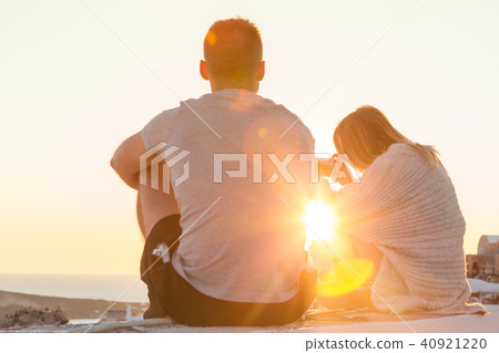 Couple watching sunrise and taking vacation photos at Santorini island, Greece. Couple watching sunrise and taking vacation photos at Santorini island, Greece. 40921220
