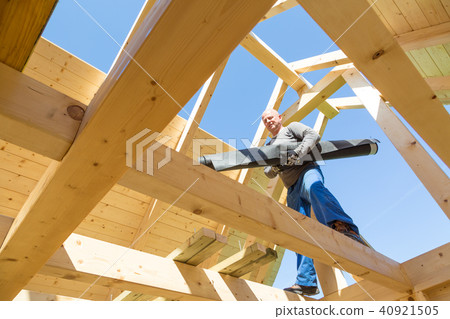 Builder at work with wooden roof construction. Builder at work with wooden roof construction. 40921505