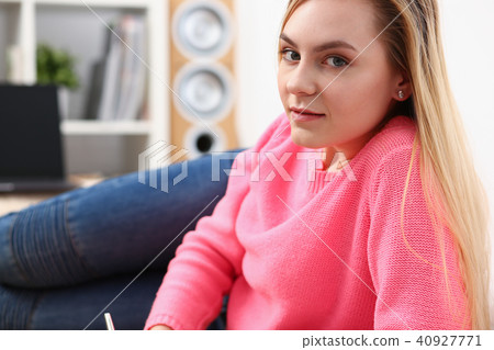 young beautiful blond woman lie on the floor read book 40927771