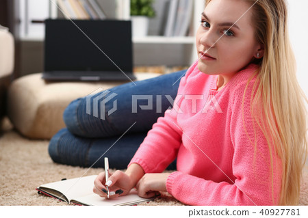 young beautiful blond woman lie on the floor read book 40927781