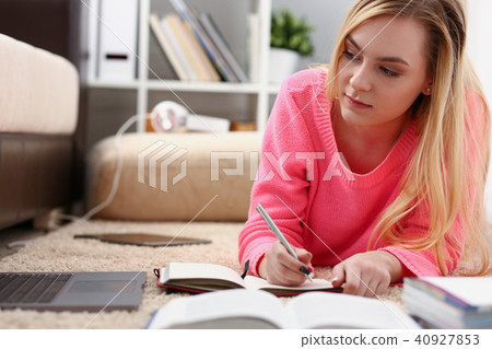 young beautiful blond woman lie on the floor read book 40927853
