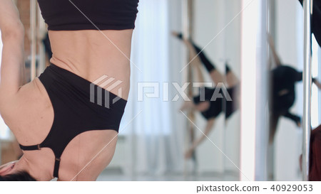 Young slim pole dance woman exercising in a class Young slim pole dance woman exercising in a class 40929053
