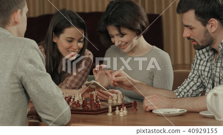 Group of young people playing chess and using smartphone 40929155