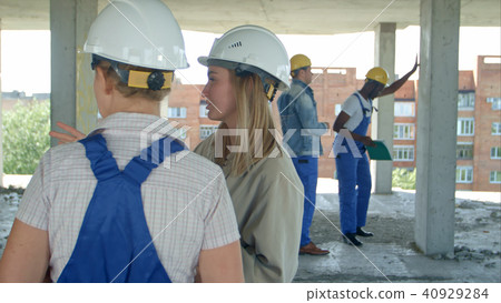 Young architecture and female worker talking at open air construction site Young architecture and female worker talking at open air construction site 40929284