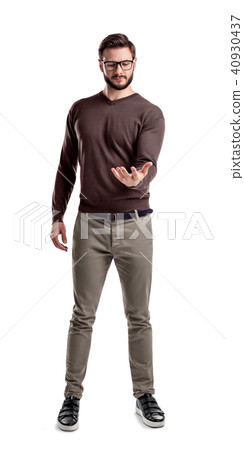 A fashionable man in glasses and casual clothes stands looking at his empty upturned hand as if 40930437