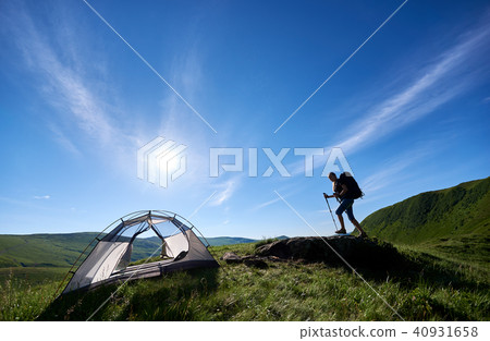 Silhouette of woman climber near camping against blue sky in the morning Silhouette of woman climber near camping against blue sky in the morning 40931658