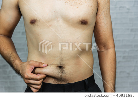 Man touching his fat belly on gray background 40931683