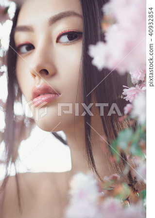 Portrait of a beautiful fantasy asian girl outdoors against natural spring flower background. Portrait of a beautiful fantasy asian girl outdoors against natural spring flower background. 40932854