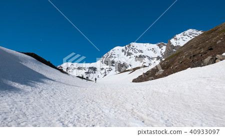 Alpinist hiking ski touring on snowy slope 40933097