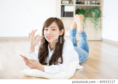 一位女士躺下來觸摸智能手機 40933117