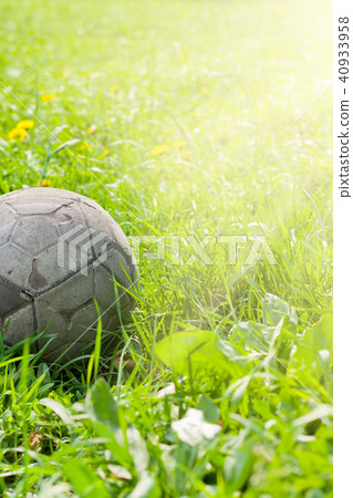 Old soccer ball on the green grass Old soccer ball on the green grass 40933958