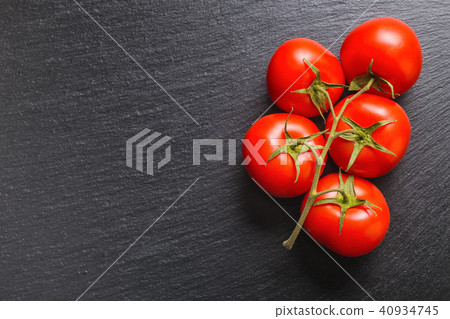 top view of beautiful red tomatoes on black slate top view of beautiful red tomatoes on black slate 40934745