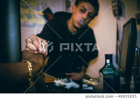 Two drug addicted young men or teenage boys sharing a marijuana  40935835