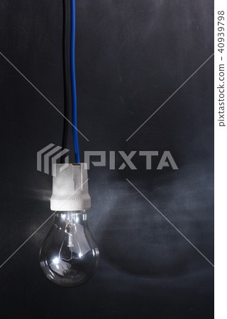 Light bulb on electric cable in dark room 40939798