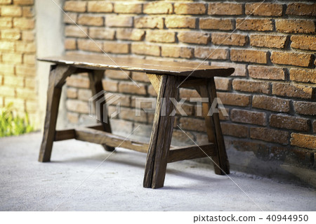 Old vintage brick wall with old wooden seat. 40944950