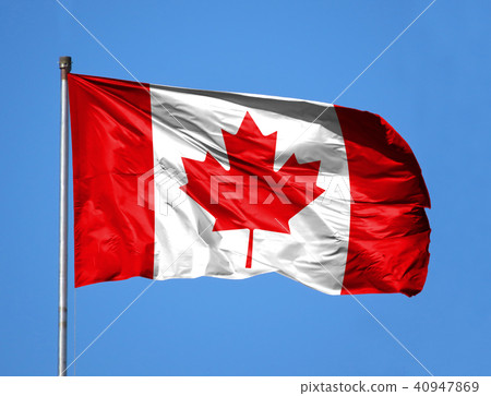 National flag of Canada on a flagpole in front of blue sky 40947869