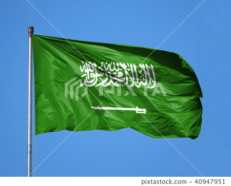 National flag of Saudi Arabia on a flagpole in front of blue sky National flag of Saudi Arabia on a flagpole in front of blue sky 40947951