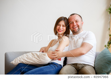 Image of smiling married couple sitting on sofa Image of smiling married couple sitting on sofa 40947966