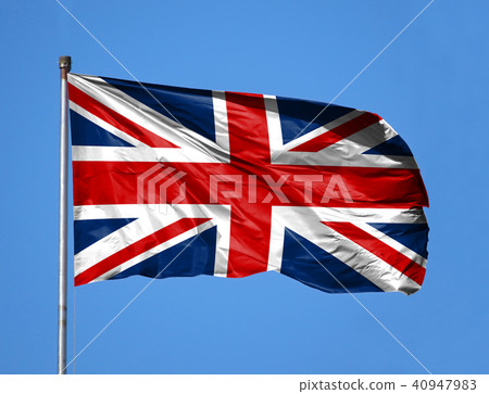 National flag of United Kingdom on a flagpole in front of blue sky 40947983