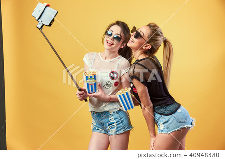 Women taking selfie with popcorn Women taking selfie with popcorn 40948380