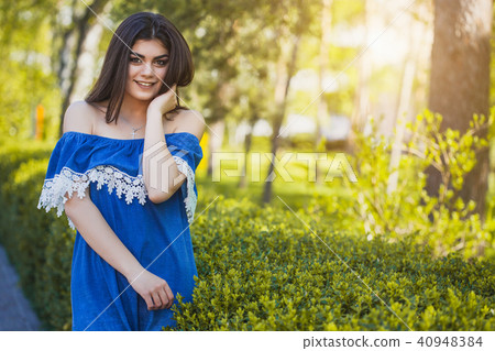 Beautiful young woman is walking in the park at sunset Beautiful young woman is walking in the park at sunset 40948384