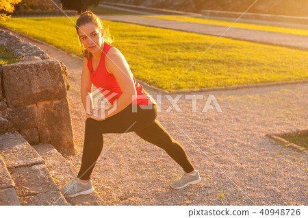 Sportswoman In Leggings And Red Top Doing Exercises 40948726