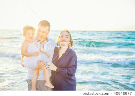 Happy family of three having fun on the beach Happy family of three having fun on the beach 40948977