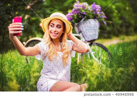 beautiful young girl with vintage bicycle and flowers on city ba beautiful young girl with vintage bicycle and flowers on city ba 40948998