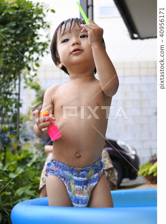 Water play in a plastic pool (1 year old boy) 40956171