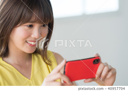 A woman who operates a smartphone 40957704