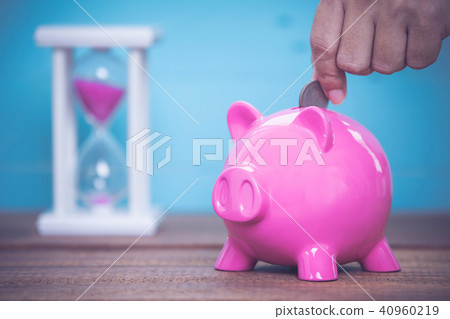 Saving, male hand putting a coin into piggy bank. Saving, male hand putting a coin into piggy bank. 40960219