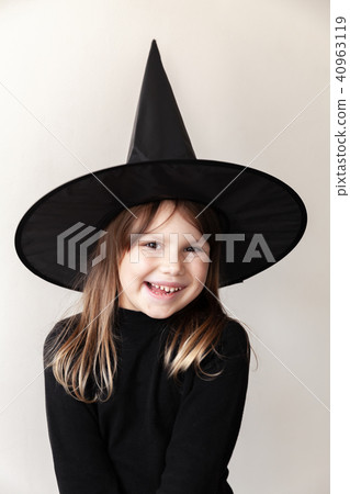 Little blond girl in black witch costume smiles Little blond girl in black witch costume smiles 40963119