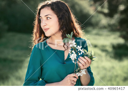 beautiful woman posing on a glade in the city park 40965417