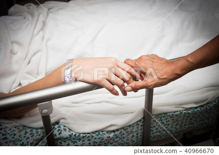 An old wrinkled hand touches and holds young hand 40966670