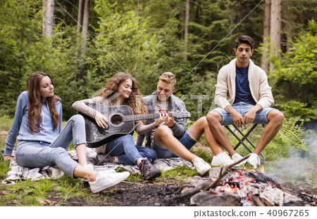 Teenagers wit a guitar camping in forest. 40967265