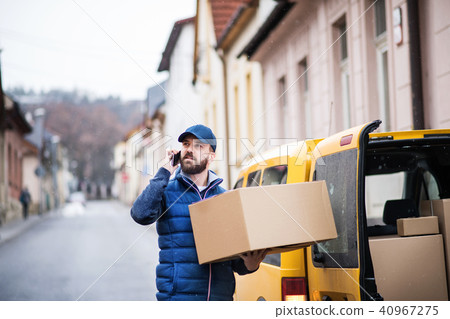 Delivery man with a parcel box on the street. Delivery man with a parcel box on the street. 40967275